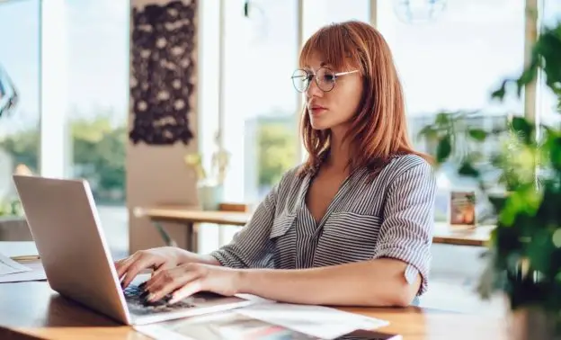 Frau arbeitet konzentriert an einem Excel Kurs am Laptop